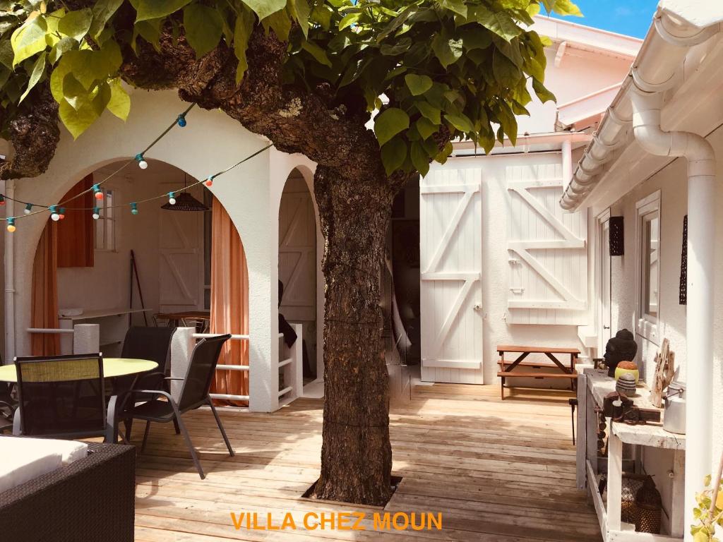 安德诺莱斯贝恩Villa Chez Moun - Plage Betey 5 min的庭院里的树,配有桌椅