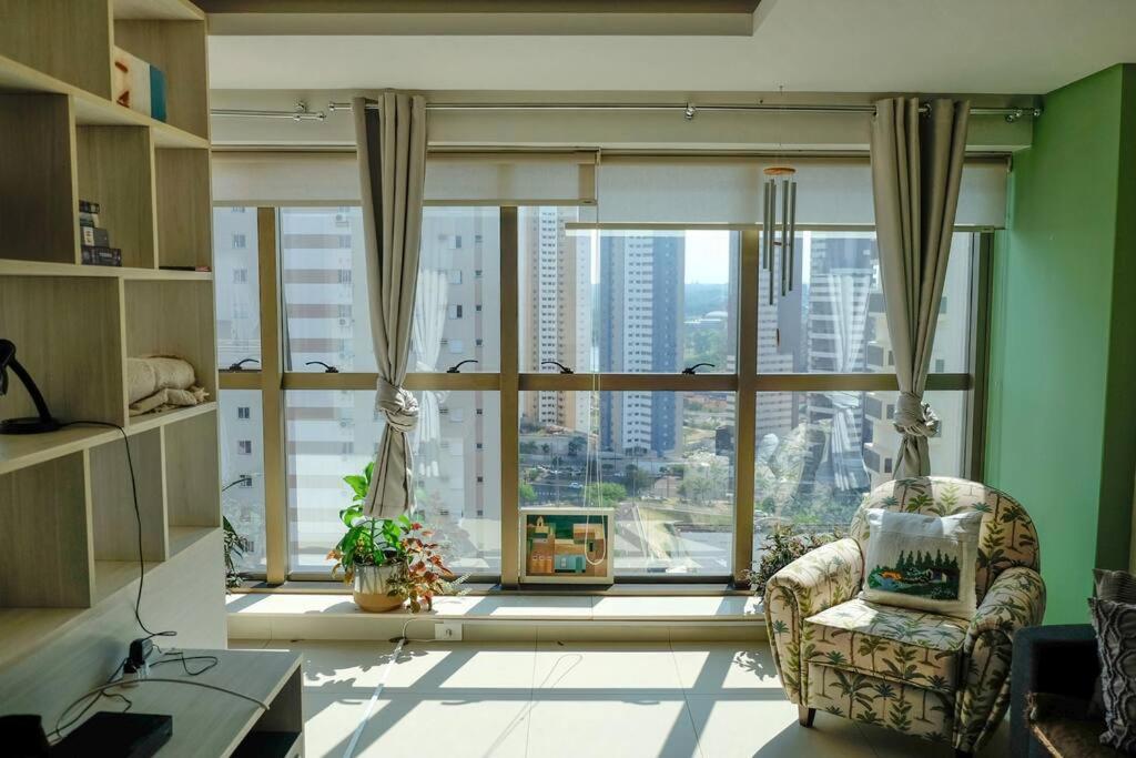 大坎普FLAT com piscina, vista para o Aquário e Feng Shui的客厅设有大窗户和椅子