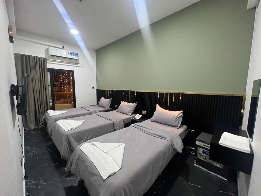 迪拜GUEST INN HOTEL的带白色枕头的四张床