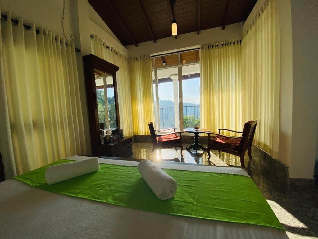 康提Kandyan View Homestay -For Foreign的一间卧室配有一张带绿色床单的床和窗户。