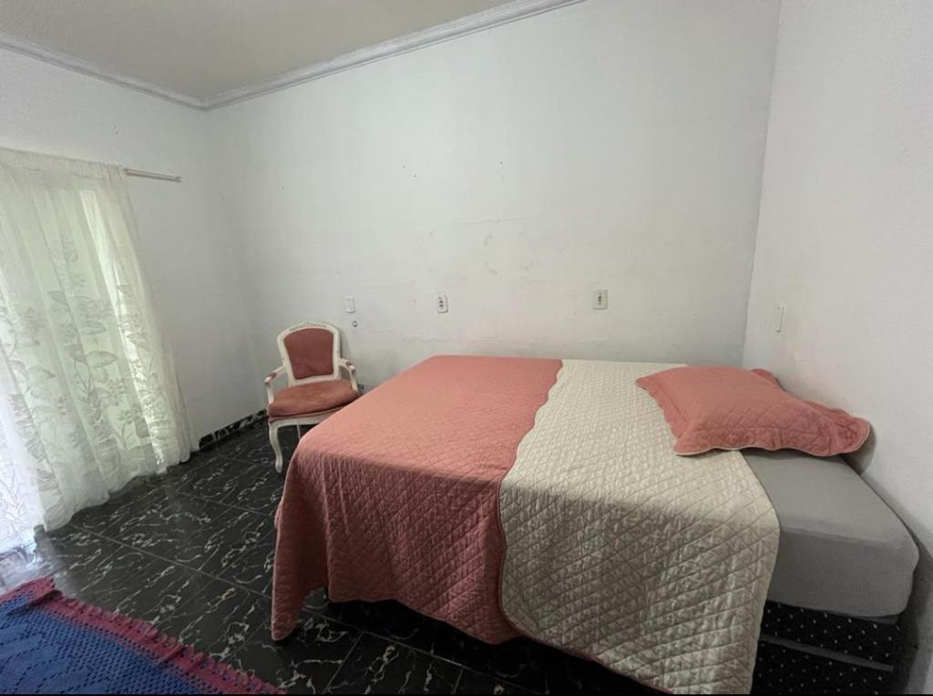 索里苏Pensão da Rose的一间卧室配有一张床和一把椅子