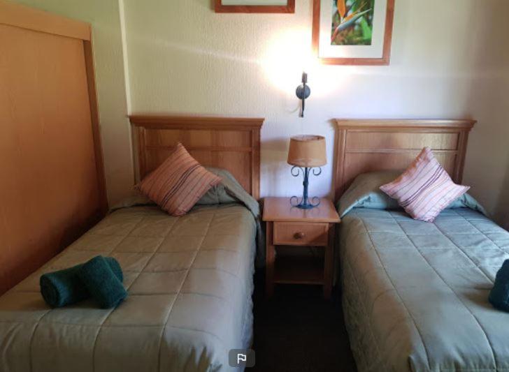德拉肯斯堡花园Fairways resort 6 sleeper unit的两张睡床彼此相邻,位于一个房间里