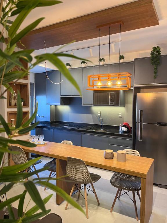 里贝朗普雷托Fiusa Dream 153的厨房配有木桌和冰箱。