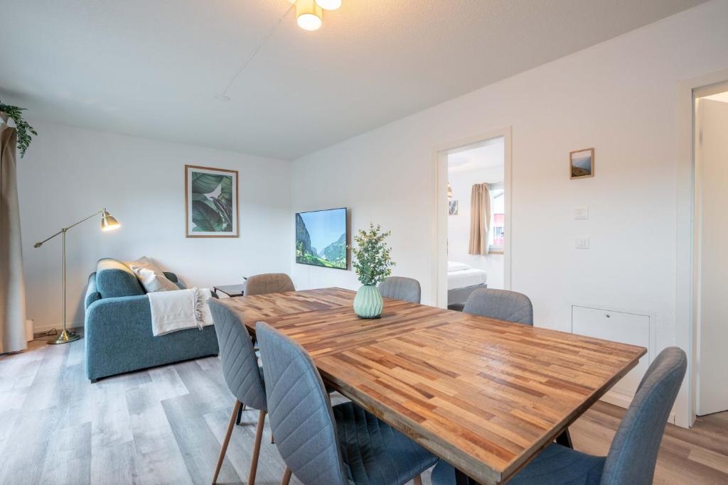 奥斯特蒙迪根Moderne Wohnung mit Parkplatz - Top Floor的用餐室以及带木桌和椅子的客厅。