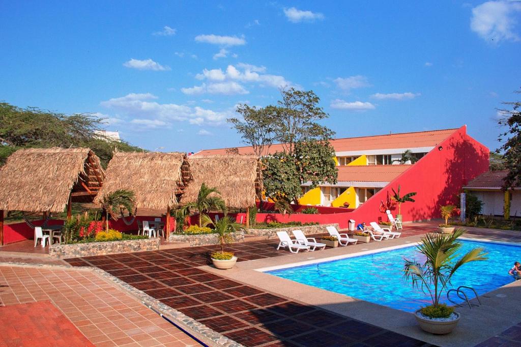里奥阿查Hotel Gimaura的一座带游泳池的度假村,位于一座建筑旁边