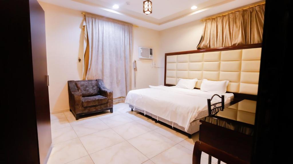 Al QunfudhahRu'a Al Qunfudhah Furnished Units的配有一张床和一把椅子的酒店客房
