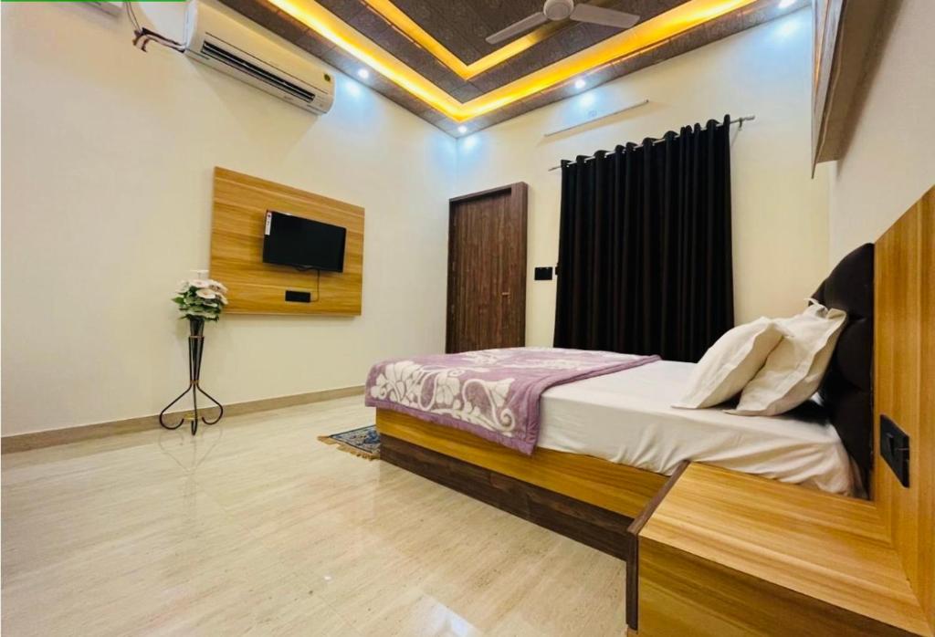 乌贾因Lotus Palm Retreat - Full Villa (By A.P. Villa's)的卧室配有一张床,墙上配有电视。