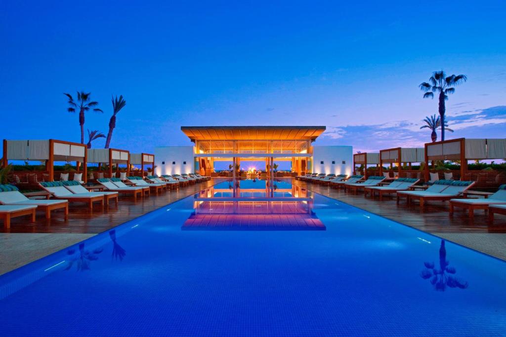 帕拉卡斯Hotel Paracas, a Luxury Collection Resort, Paracas的一个带椅子的度假泳池和夜间凉亭