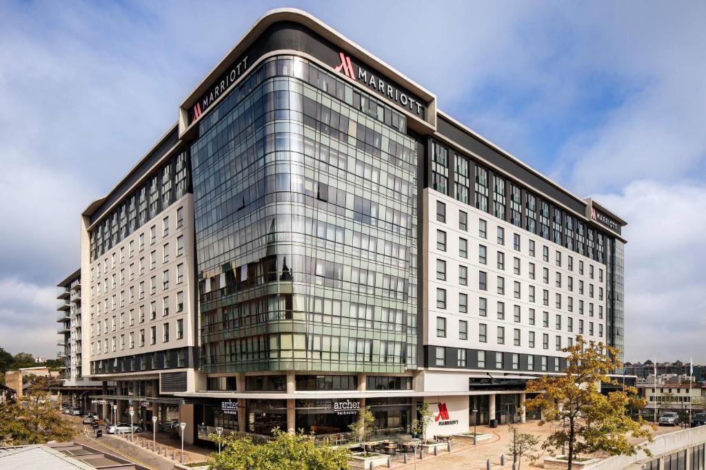 约翰内斯堡Johannesburg Marriott Hotel Melrose Arch的一座白色的大建筑,上面有标志