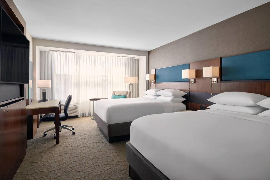 Menomonee FallsDelta Hotels by Marriott Milwaukee Northwest的酒店客房配有两张床和一张书桌