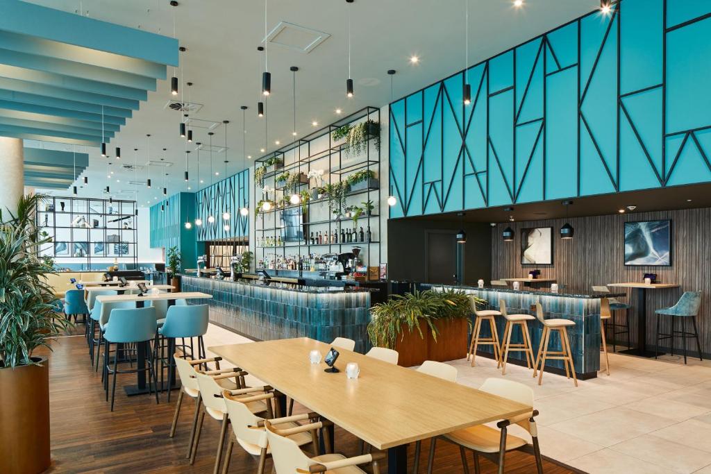 霍利伦敦盖特威克机场万怡酒店的一间带桌椅的餐厅和一间酒吧