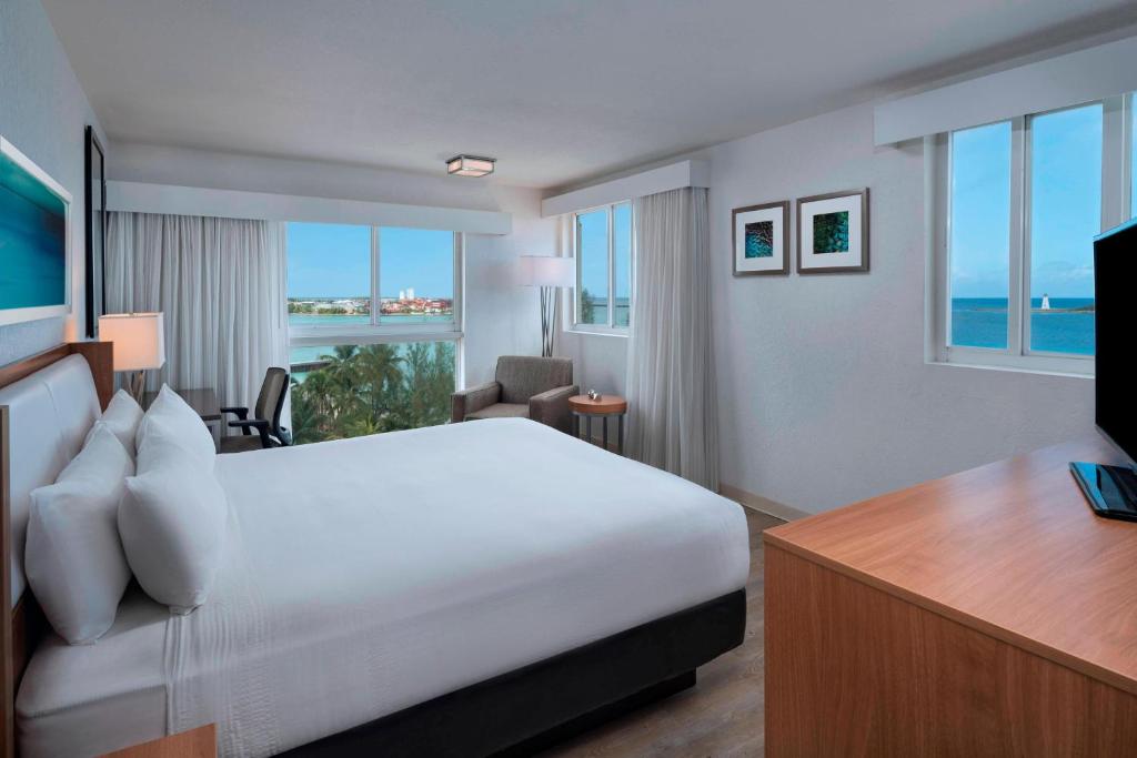 拿骚拿骚市区/贾卡努海滩万怡酒店的酒店客房设有一张床、一张书桌和窗户。