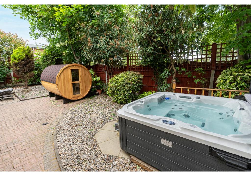Canvey IslandNature's Serenade:3BR Classic Home-Jacuzzi & Sauna的一个带围栏的庭院内的按摩浴缸