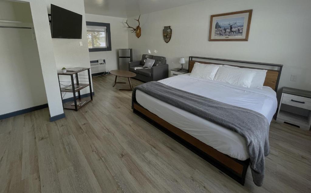 SalmonSacajawea Inn的一间卧室配有一张大床和一把椅子