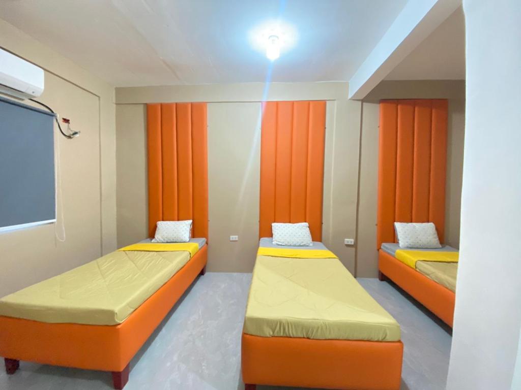 TinajeroXYC Hostel的橙色窗帘间内的两张床
