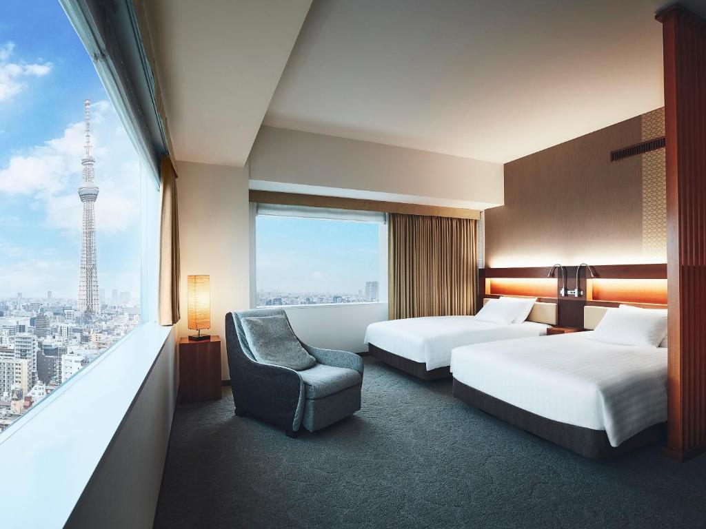 东京锦糸町乐天城市酒店的酒店客房带两张床、椅子和窗户