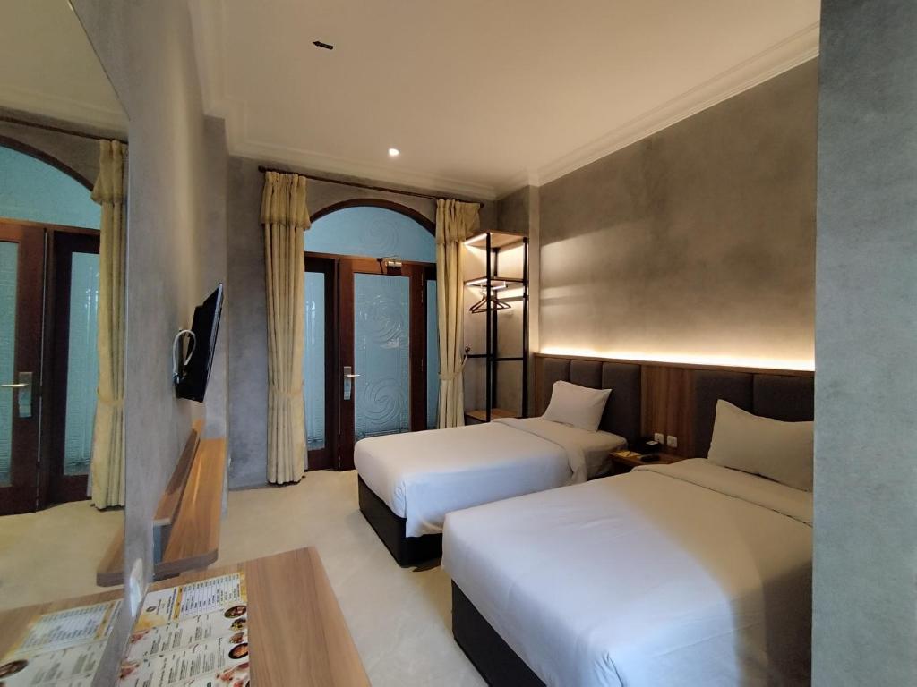 玛琅马朗大皇宫酒店的酒店客房设有两张床和一张桌子。