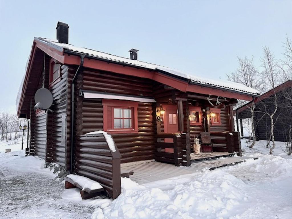 基尔匹斯扎我维Villa Tsahkal Kilpisjärvi的雪地小木屋,带门廊