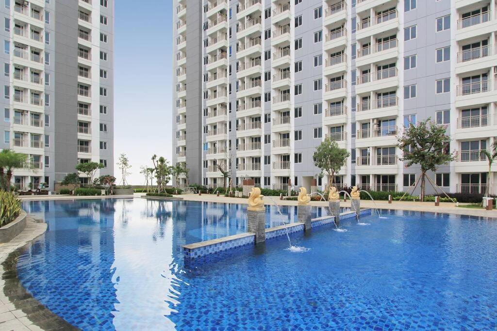 泗水Apartement orchard Surabaya的两个高楼前的大型游泳池