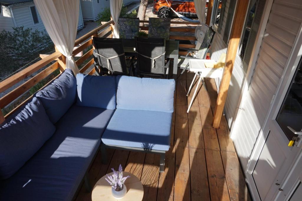 耶泽拉DM mobile home的一个带蓝色沙发和桌子的门廊
