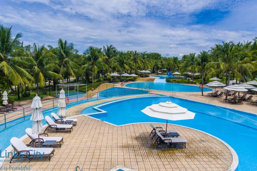 Ấp Bình HưngSealink Beach Villa PE48- PE69的度假酒店的游泳池配有躺椅和遮阳伞