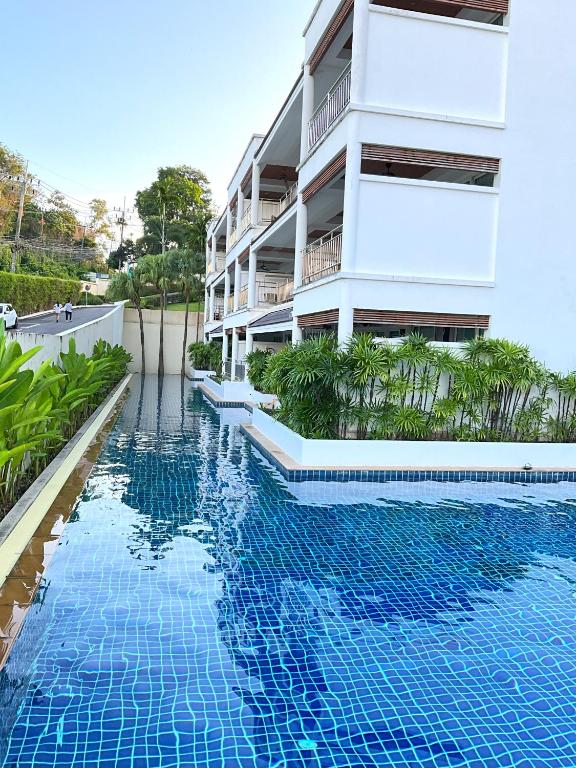 攀瓦海滩Bel Air Cape Panwa Resort Phuket的大楼前的游泳池