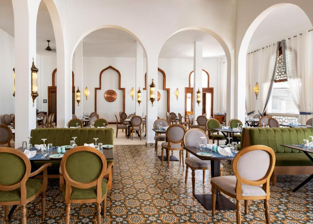 普瓦尼梅查恩加尼LUX Marijani Zanzibar的一间在房间内配有桌椅的餐厅