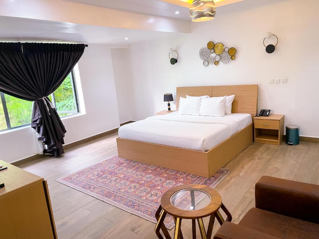 阿布贾Address hotels and towers的一间卧室配有一张床、一张桌子和一张沙发