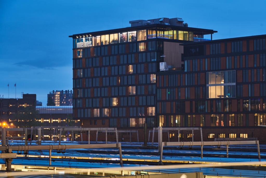 乌得勒支Inntel Hotels Utrecht Centre的一座高大的建筑,城市里灯火通明