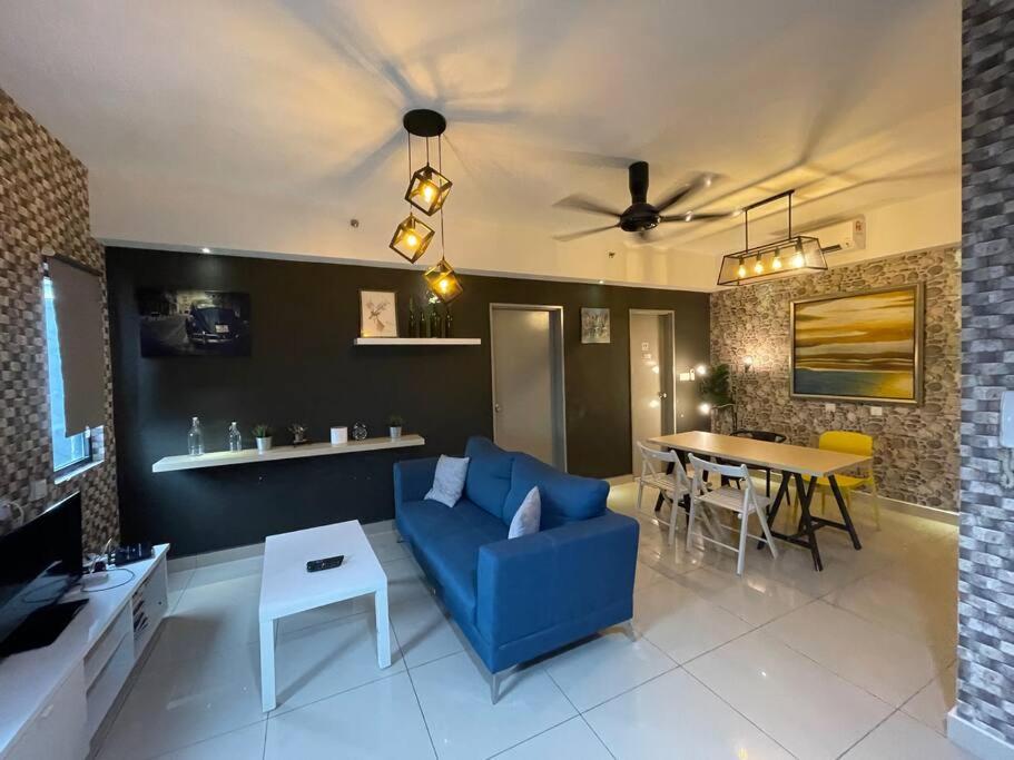 塞贝维Stylish 2-bedroom Hyve Soho Suites Near MRT的客厅配有蓝色的沙发和桌子