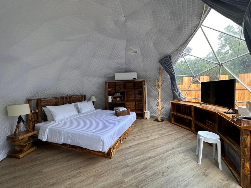清道Lhong Chiang Dao Glamping หลงเชียงดาว的一间卧室配有一张床,帐篷内配有电视