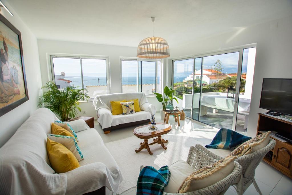 阿尔热祖尔Vila Fortaleza的客厅配有白色家具,享有海景。