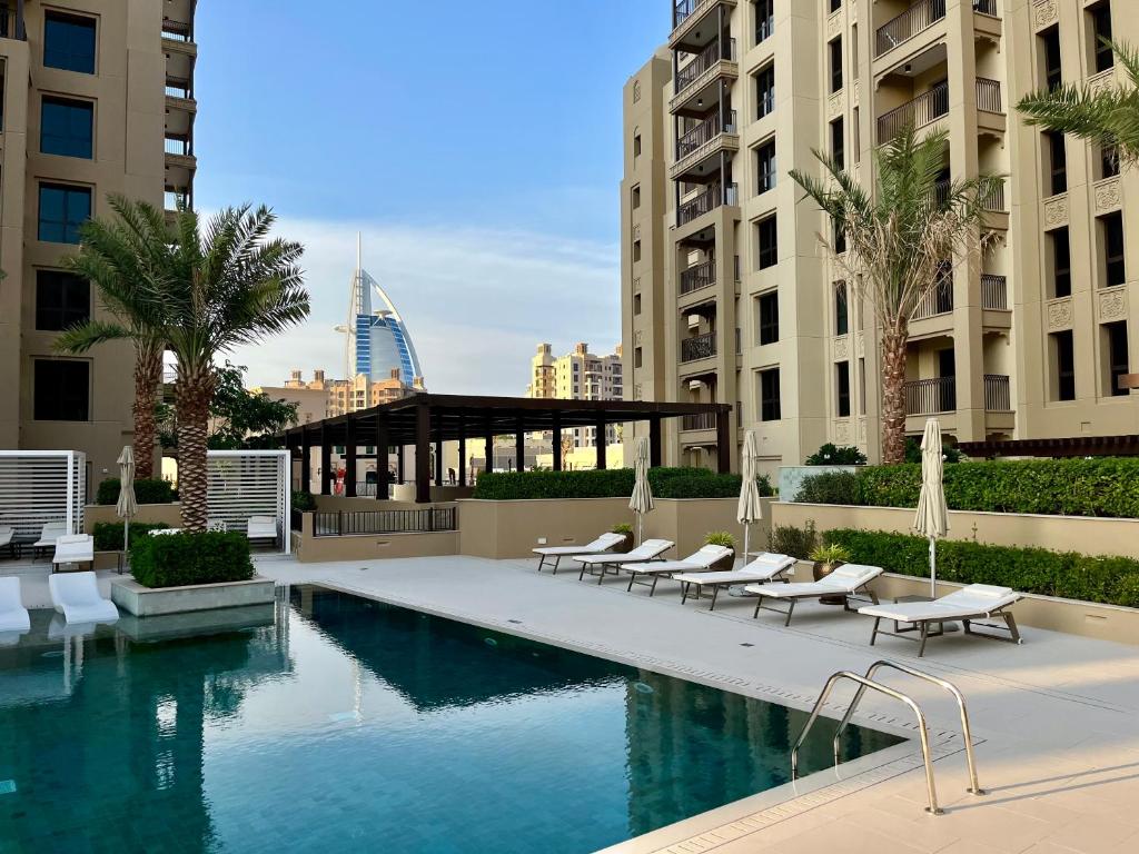 迪拜New 2 bedroom entire apartment in Madinat Jumeirah Living的一座带躺椅的游泳池和一座建筑