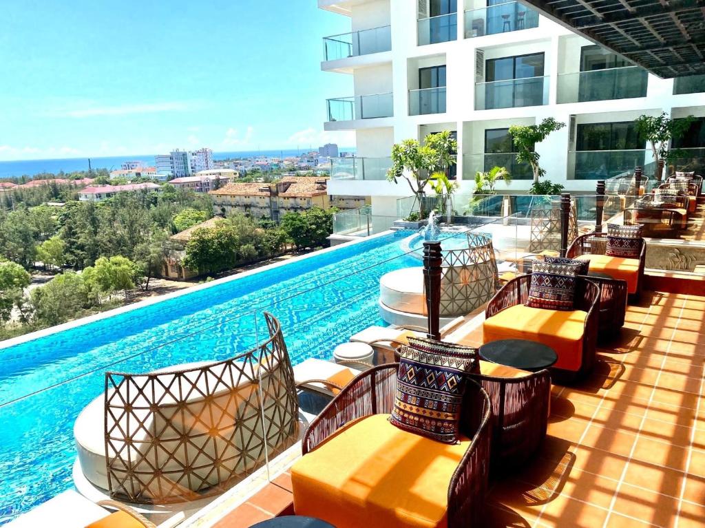 莲三Apec Mandala Phu Yen Condotel的酒店庭院设有椅子和游泳池