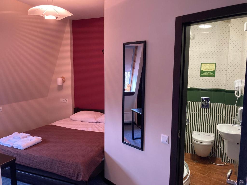 哈尔科夫Міні-готель Тремпель的客房设有床、水槽和镜子