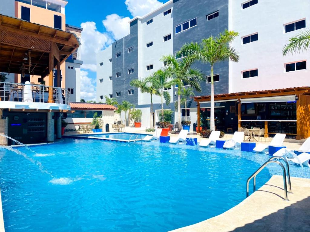 拉罗马纳Halibut Hotel的一座游泳池,位于酒店,设有椅子和建筑