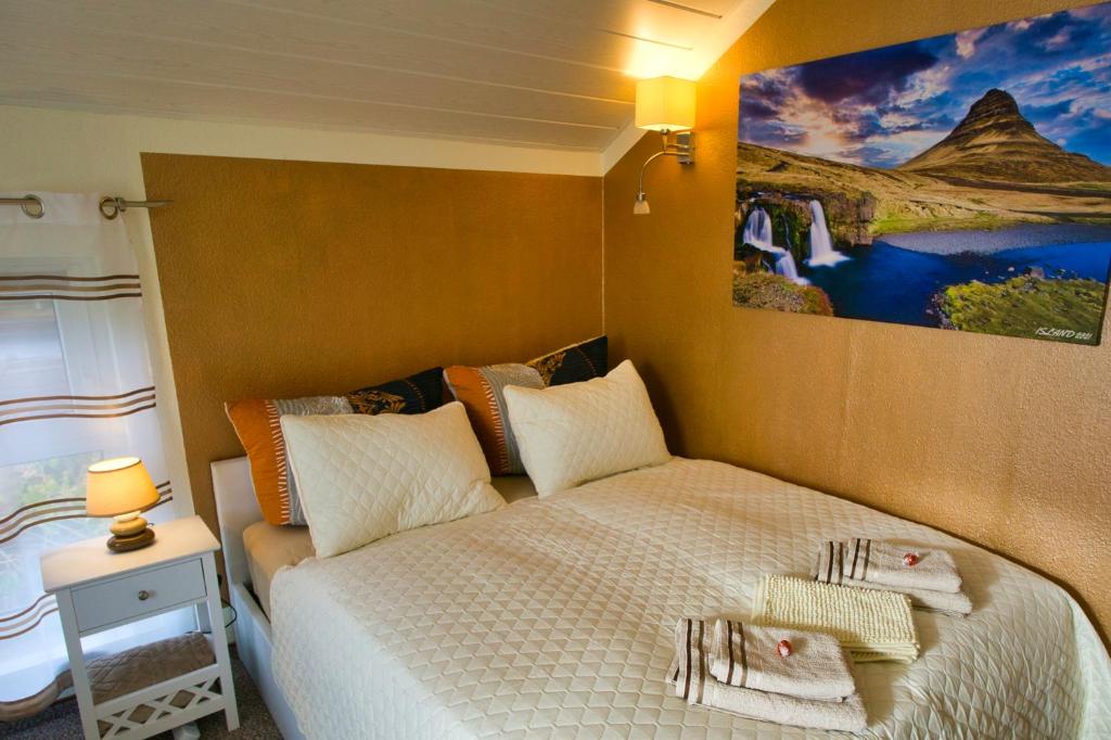 德累斯顿My CozyPlace - Zimmer für Zwei的卧室配有一张床,墙上挂有绘画作品