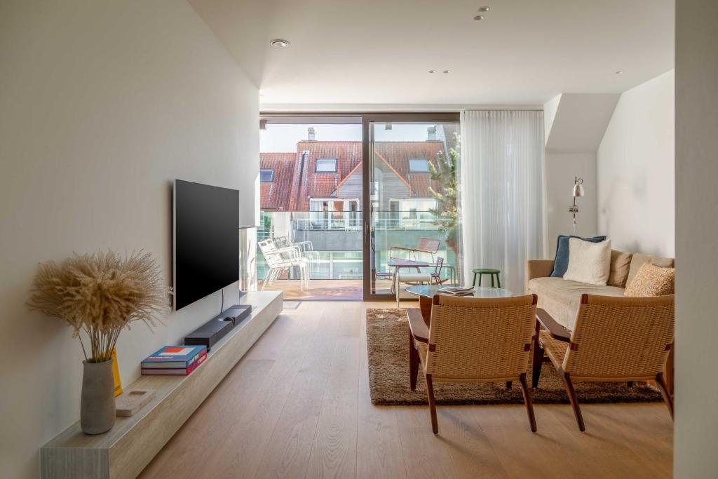 克诺克－海斯特Stunning duplex - 3 bedroom - 2 sunny terrasses的客厅配有电视和桌椅