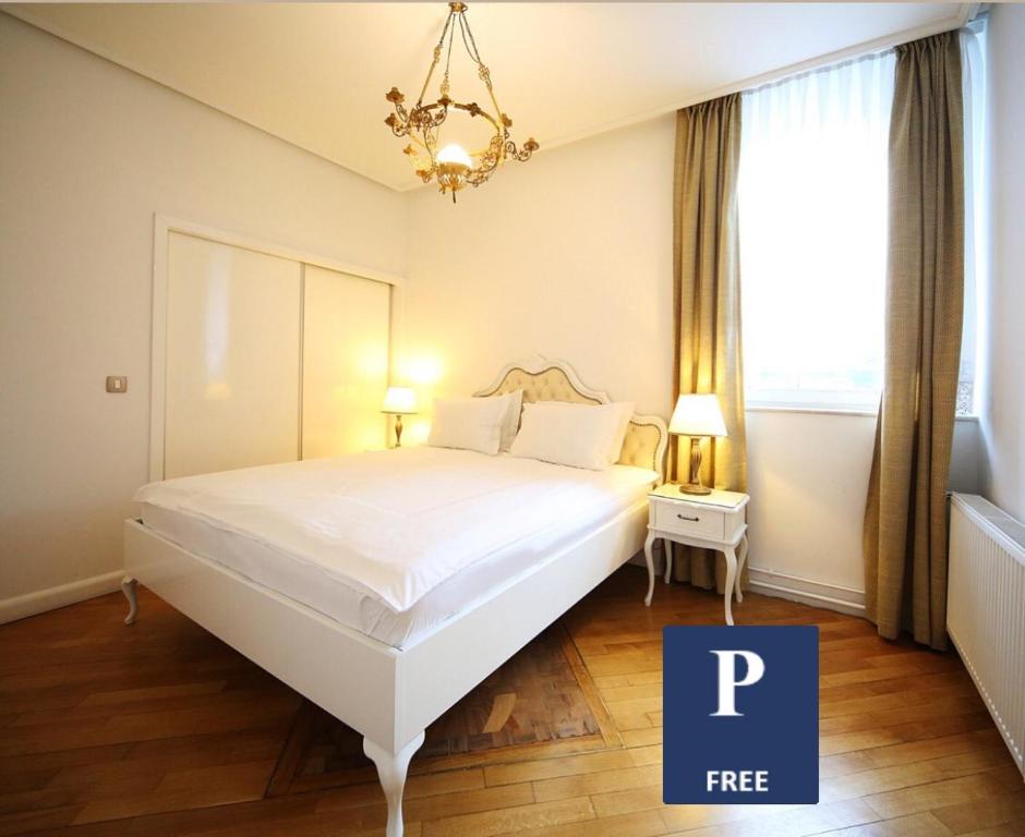 卢布尔雅那维拉明卡公寓式酒店的卧室配有一张带吊灯的大型白色床。