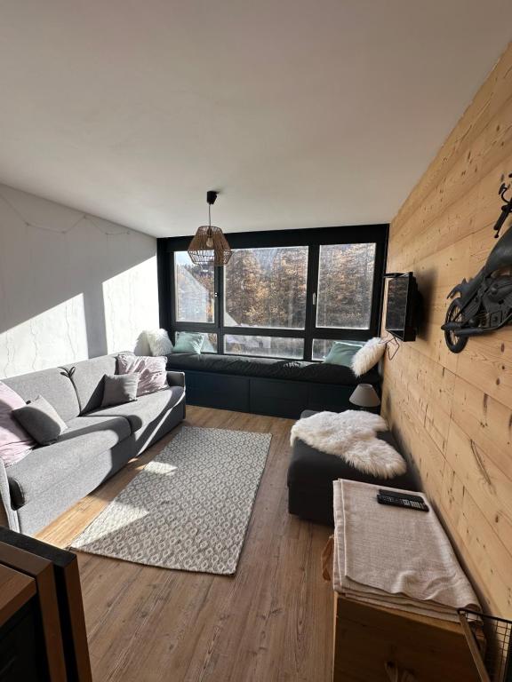 瓦尔SKI AUX PIEDS的带沙发和大窗户的客厅