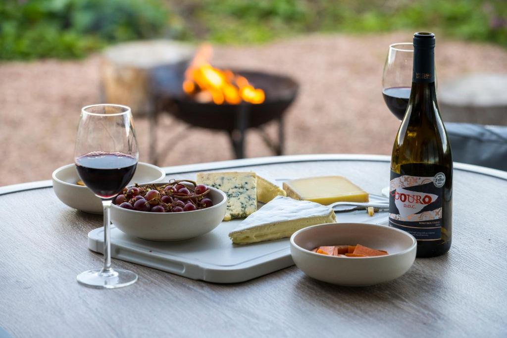 圣安德鲁斯Off Grid Travel at Cambo Estate的一张桌子,上面放着一盘食物和一瓶葡萄酒