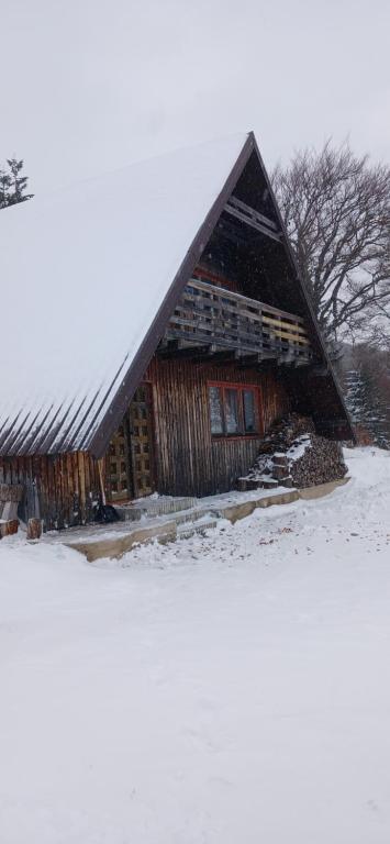 福伊尼察Samostanska kuća的雪覆盖的田野里的一个大型木制谷仓