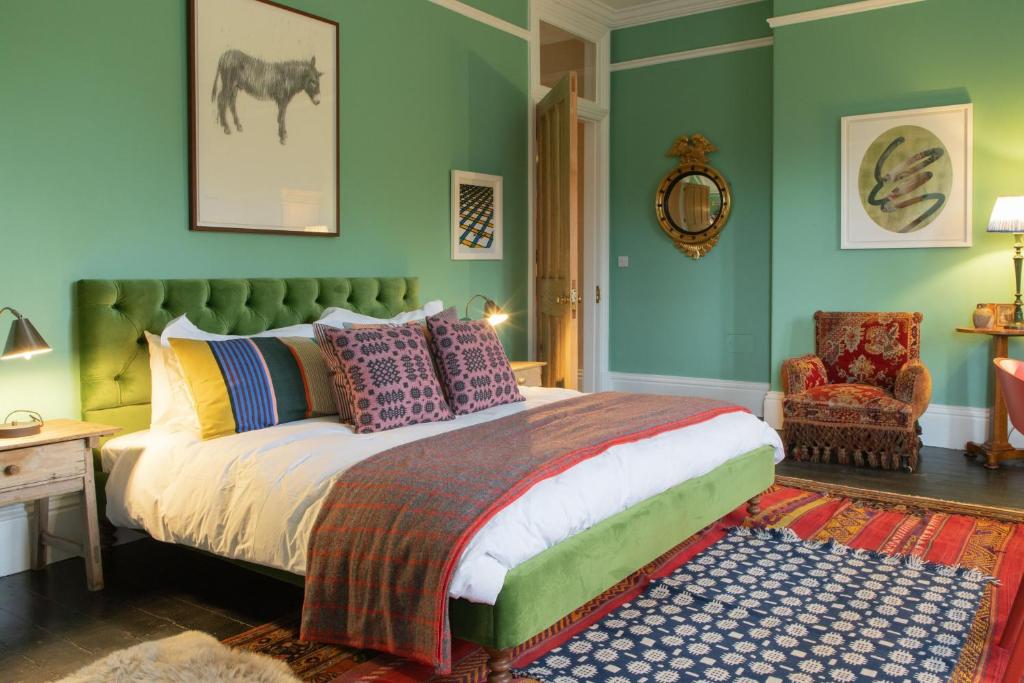 HawardenThe West End - Hawarden Castle的一间卧室配有一张带色彩缤纷枕头的床和一把椅子