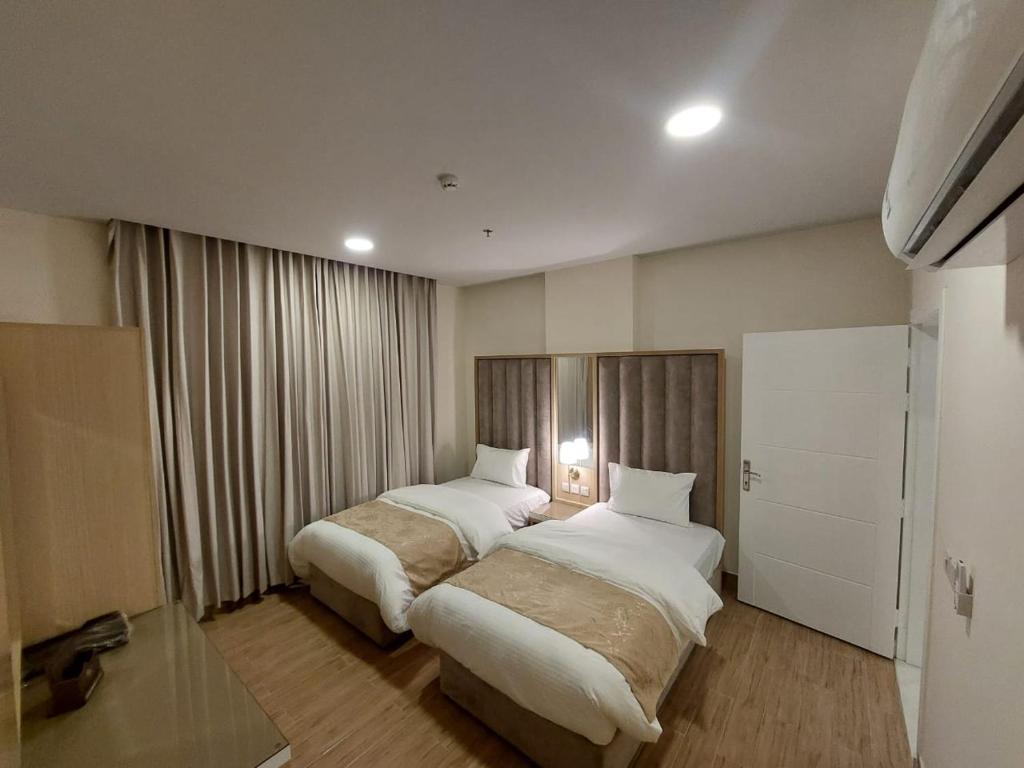 哈萨شقق كيان البستان للشقق المخدومة的酒店客房设有两张床和窗户。