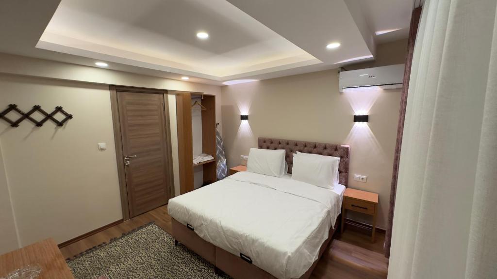 伊斯坦布尔Golden Tulip Suite Apart的卧室配有白色的床和两盏灯。