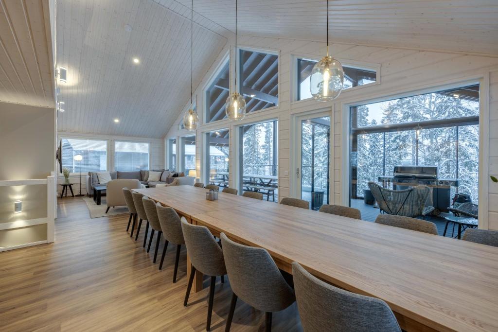 耶姆赛Luksushuvila Himos Hillside的大型用餐室配有长桌和椅子