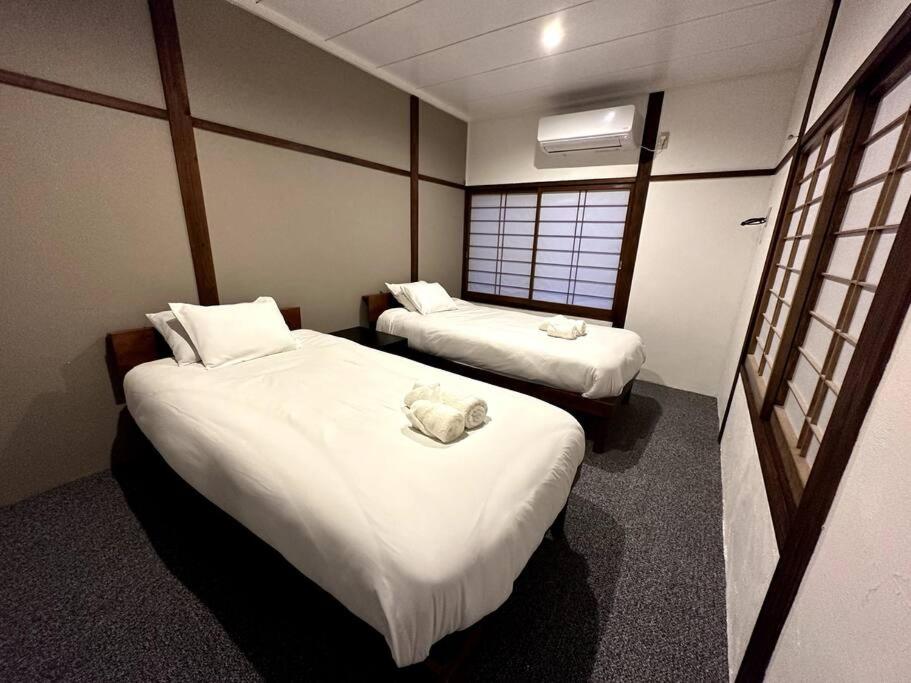 白马村AOBA Hakuba self-contained home的酒店客房设有两张床和窗户。