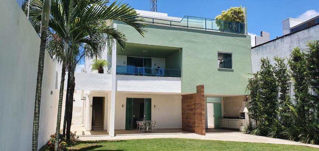 伊列乌斯Casa Vista Pontal的带阳台的别墅,种植了棕榈树
