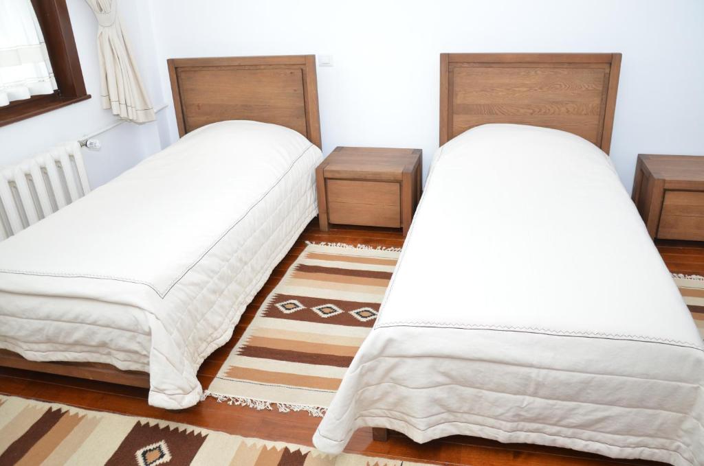 雅西Casa de Oaspeți Sfântul Nicolae的配有白色床单的客房内的两张床