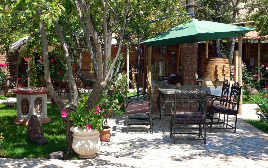 Kaji-SayArt Hotel Al Hayat的庭院配有桌椅和遮阳伞。